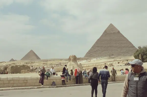 Tourists walking near the Great Pyramids and Sphinx at Giza