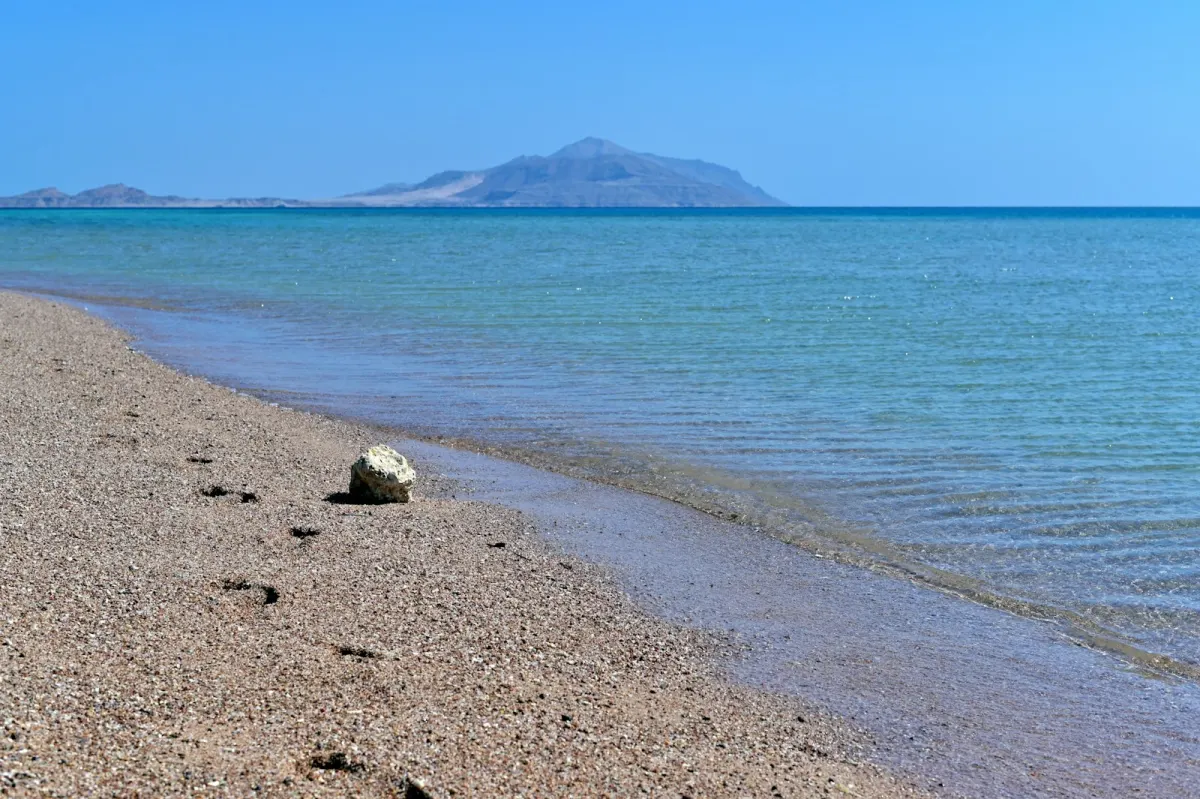 Ein ruhiger Strand, an dem Berge auf das Rote Meer treffen, bei Sharm El Sheikh