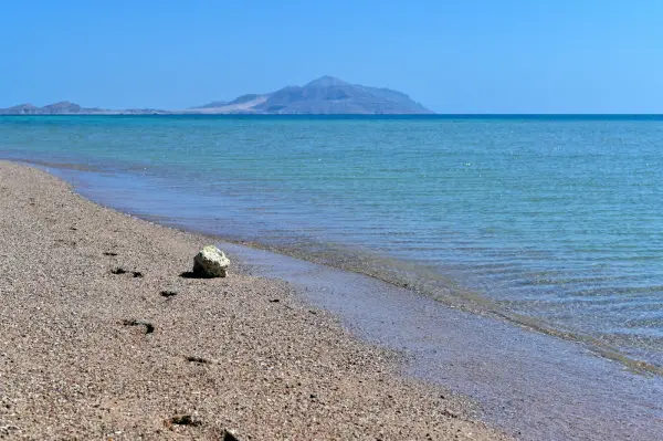 Ein ruhiger Strand, an dem Berge auf das Rote Meer treffen, bei Sharm El Sheikh